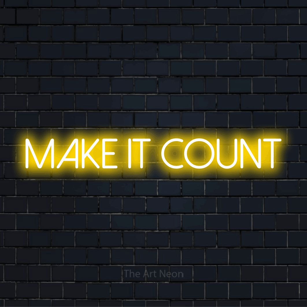 "Make It Count" script-style LED neon sign on a black brick wall