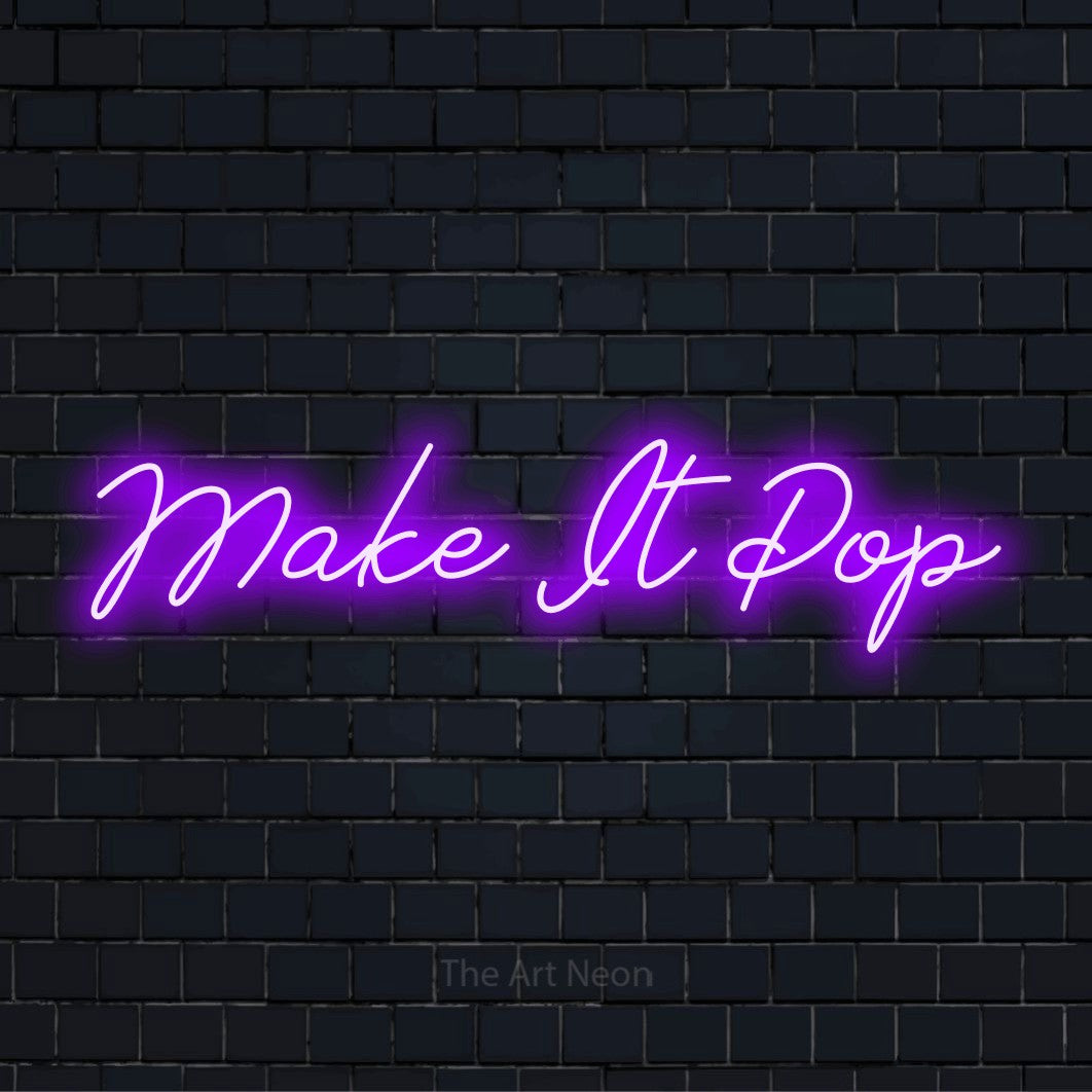 "Make It Pop" neon text design on a black brick wall