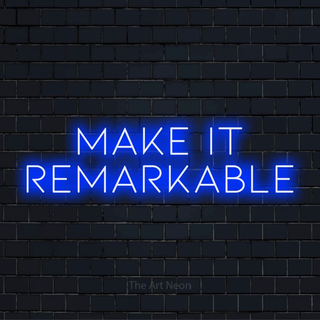 "Make It Remarkable" LED neon sign on a black brick wall