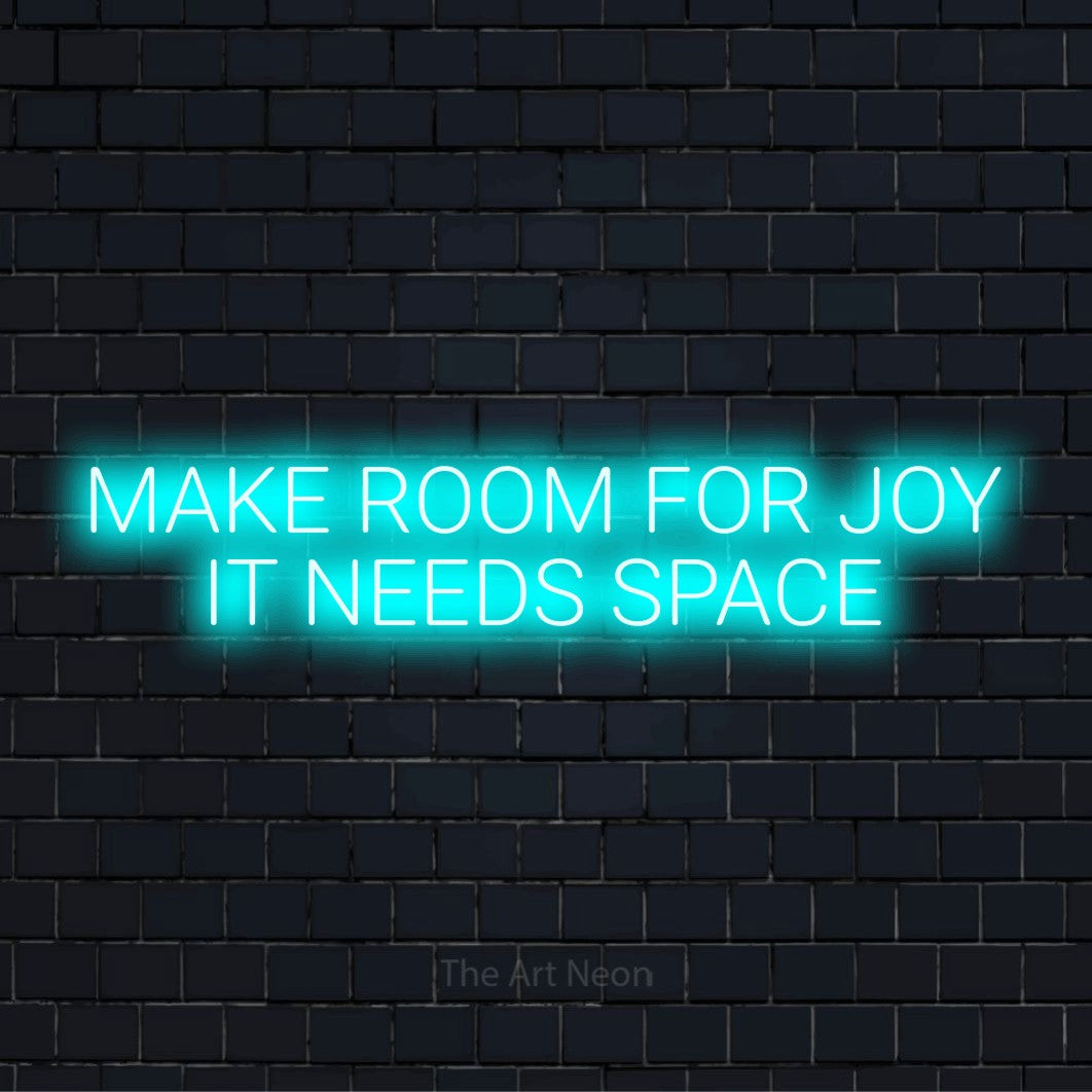 "Make Room For Joy It Needs Space" glowing LED neon sign on a black brick wall