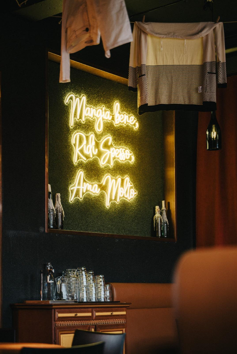 Nahaufnahme eines grünen LED-Neonschilds über einer Sitznische im Restaurant