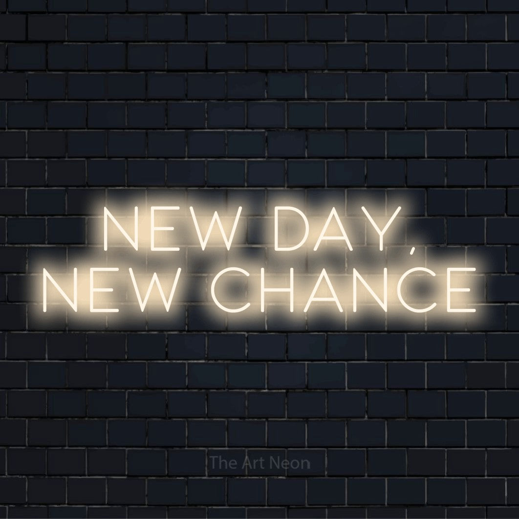 "New Day, New Chance" script-style LED neon sign on a black brick wall
