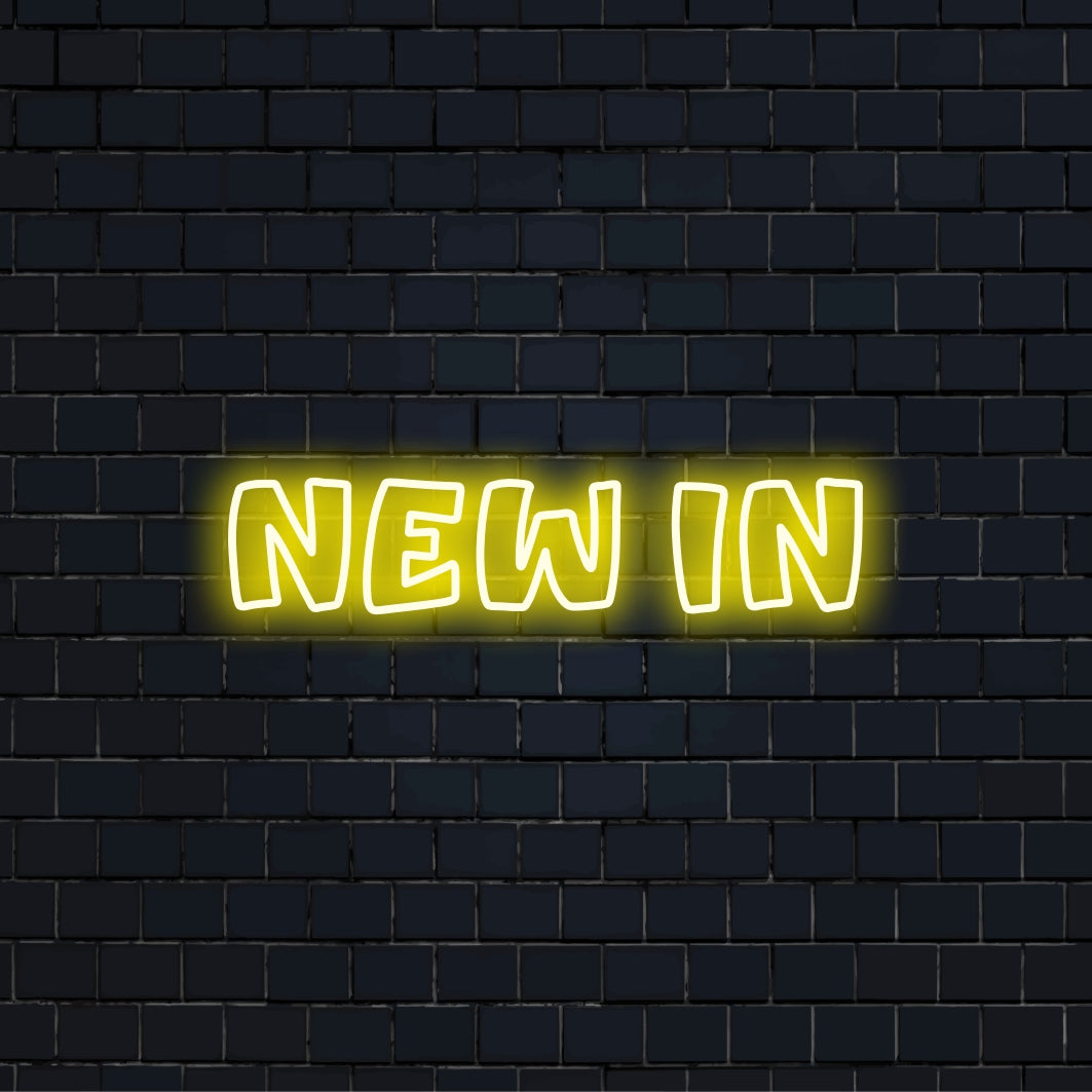 New In Neon Sign, bright LED glow against black brick wall