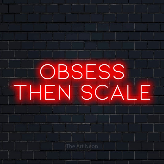 "Obsess Then Scale" neon text design on a black brick wall