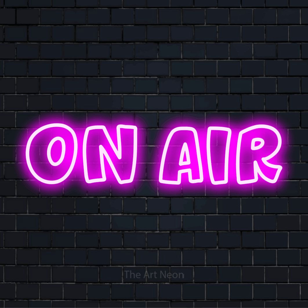 "On Air" script-style LED neon sign on a black brick wall