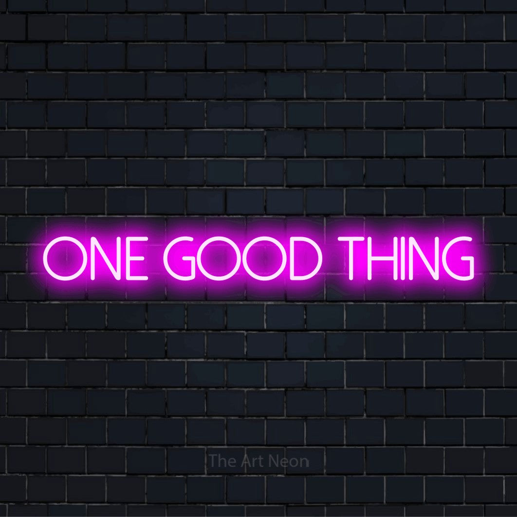 "One Good Thing" glowing LED neon sign on a black brick wall