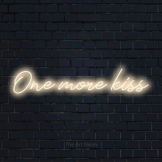 "One More Kiss" neon text design on a black brick wall