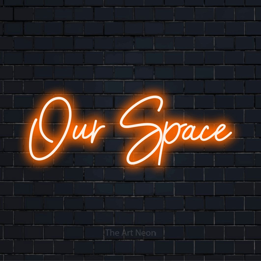 "Our Space" neon text design on a black brick wall