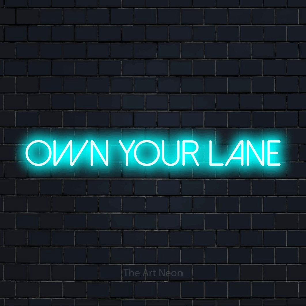 "Own Your Lane" script-style LED neon sign on a black brick wall
