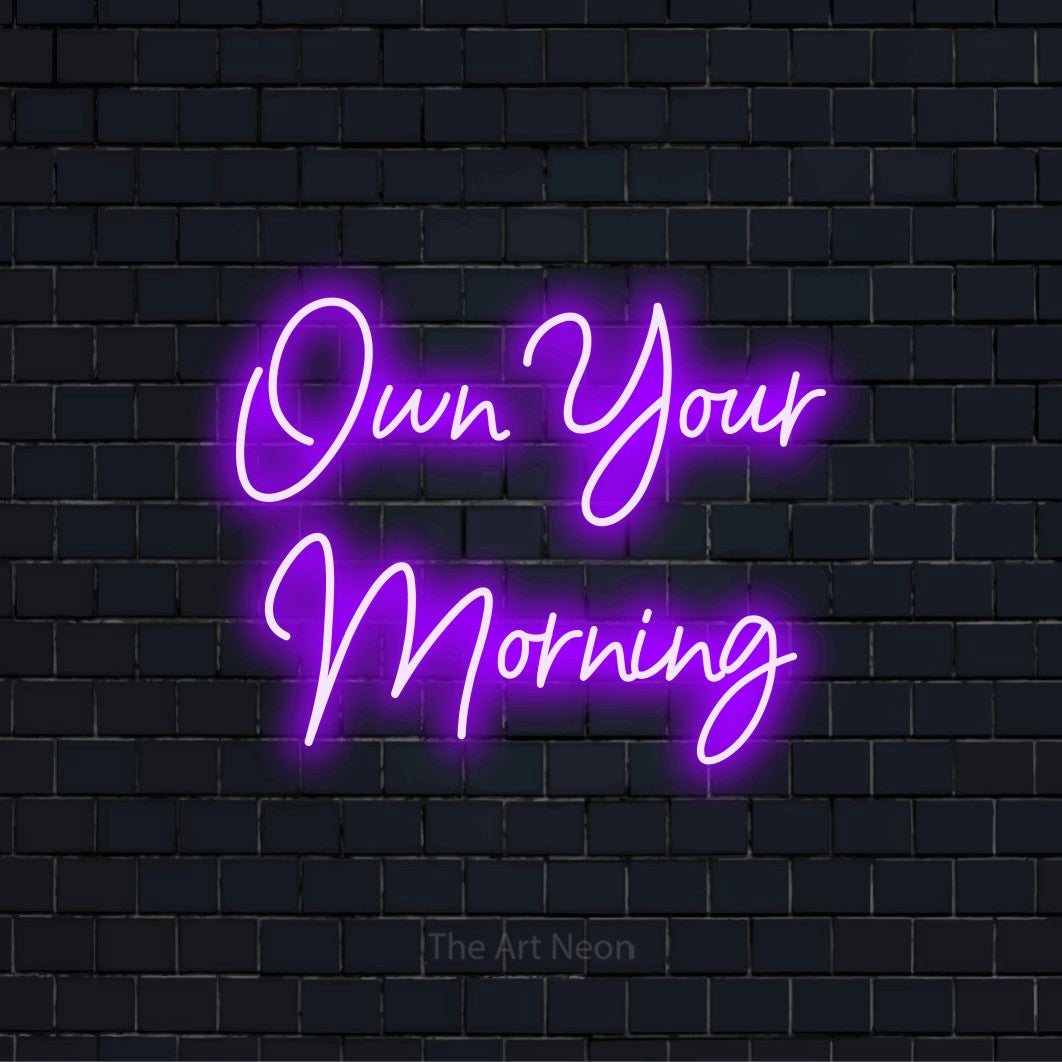 "Own Your Morning" neon text design on a black brick wall