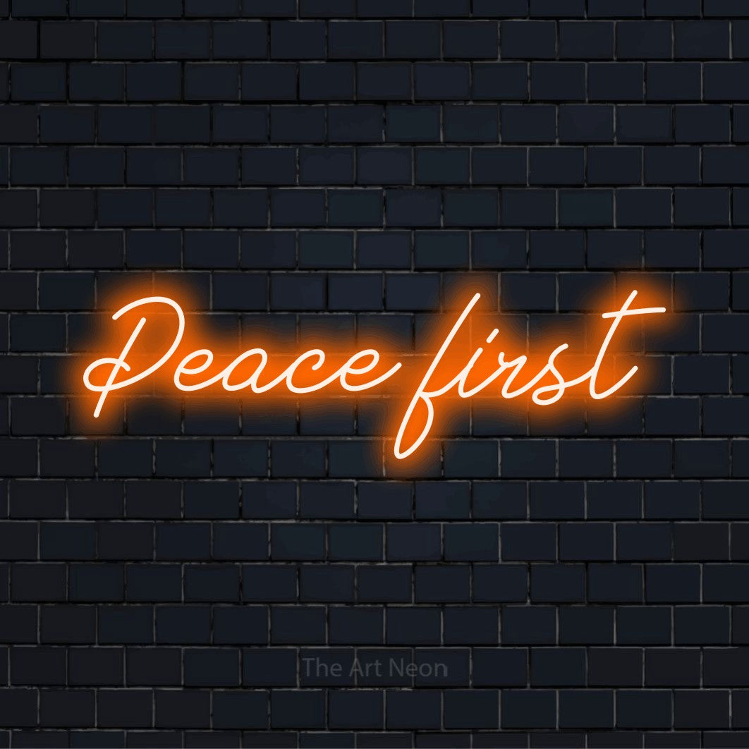 "Peace First" LED neon sign on a black brick wall