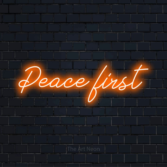 "Peace First" LED neon sign on a black brick wall