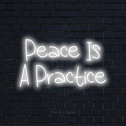 "Peace Is A Practice" LED neon sign on a black brick wall