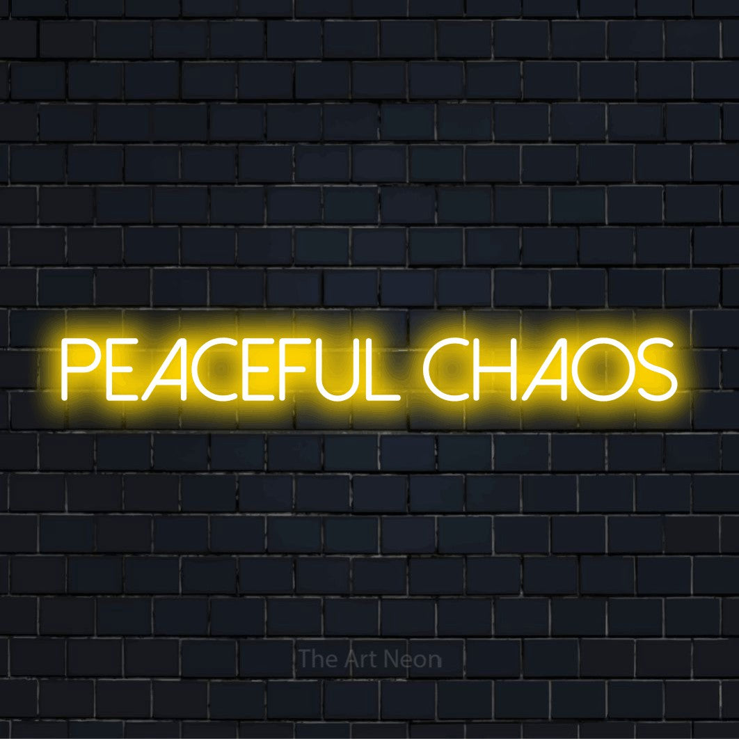 "Peaceful Chaos" text design with neon effect on a black brick wall
