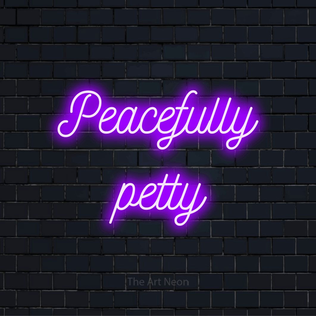 "Peacefully Petty" LED neon sign on a black brick wall