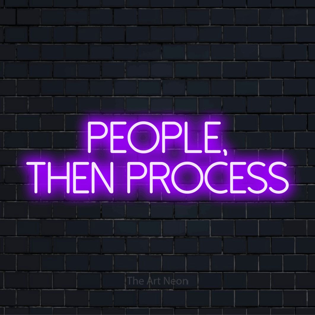 "People, Then Process" neon text design on a black brick wall