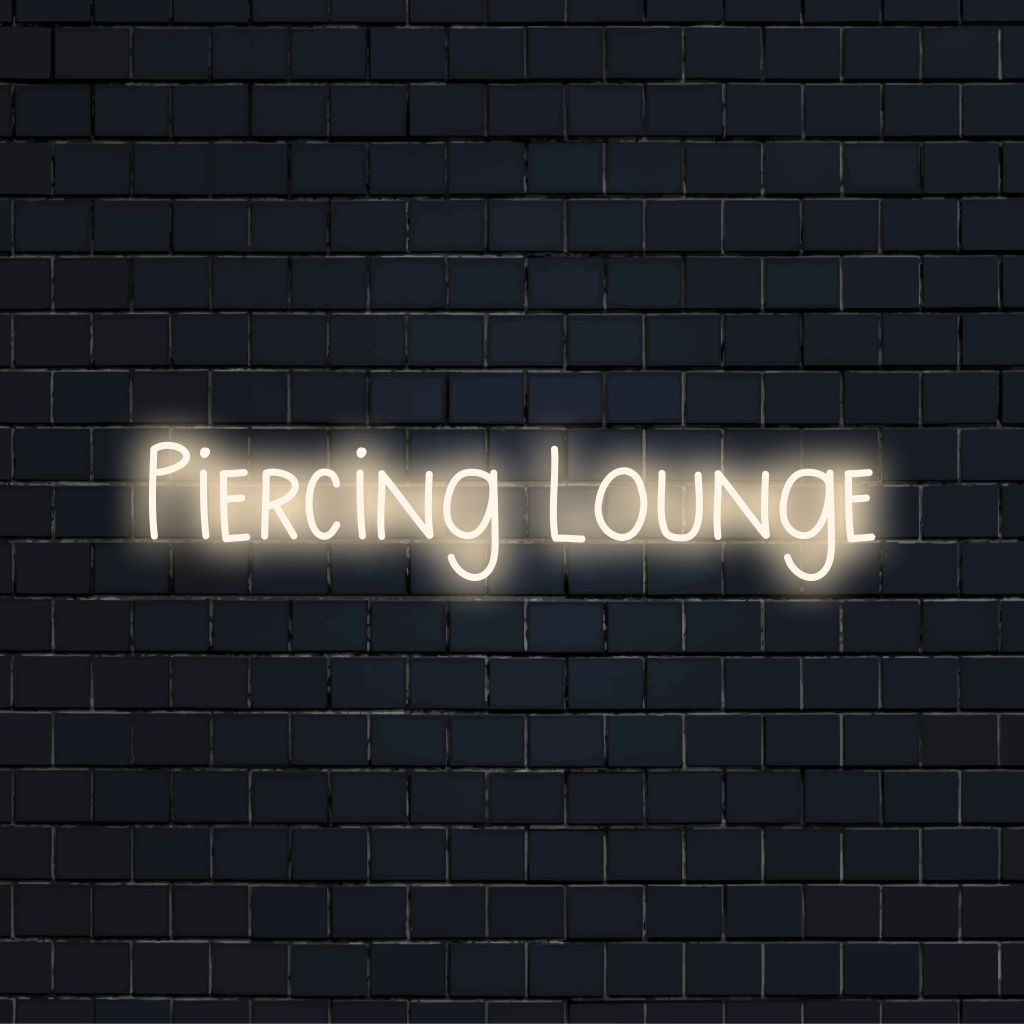 Piercing Lounge Neon Sign, glowing lettering on dark brick background