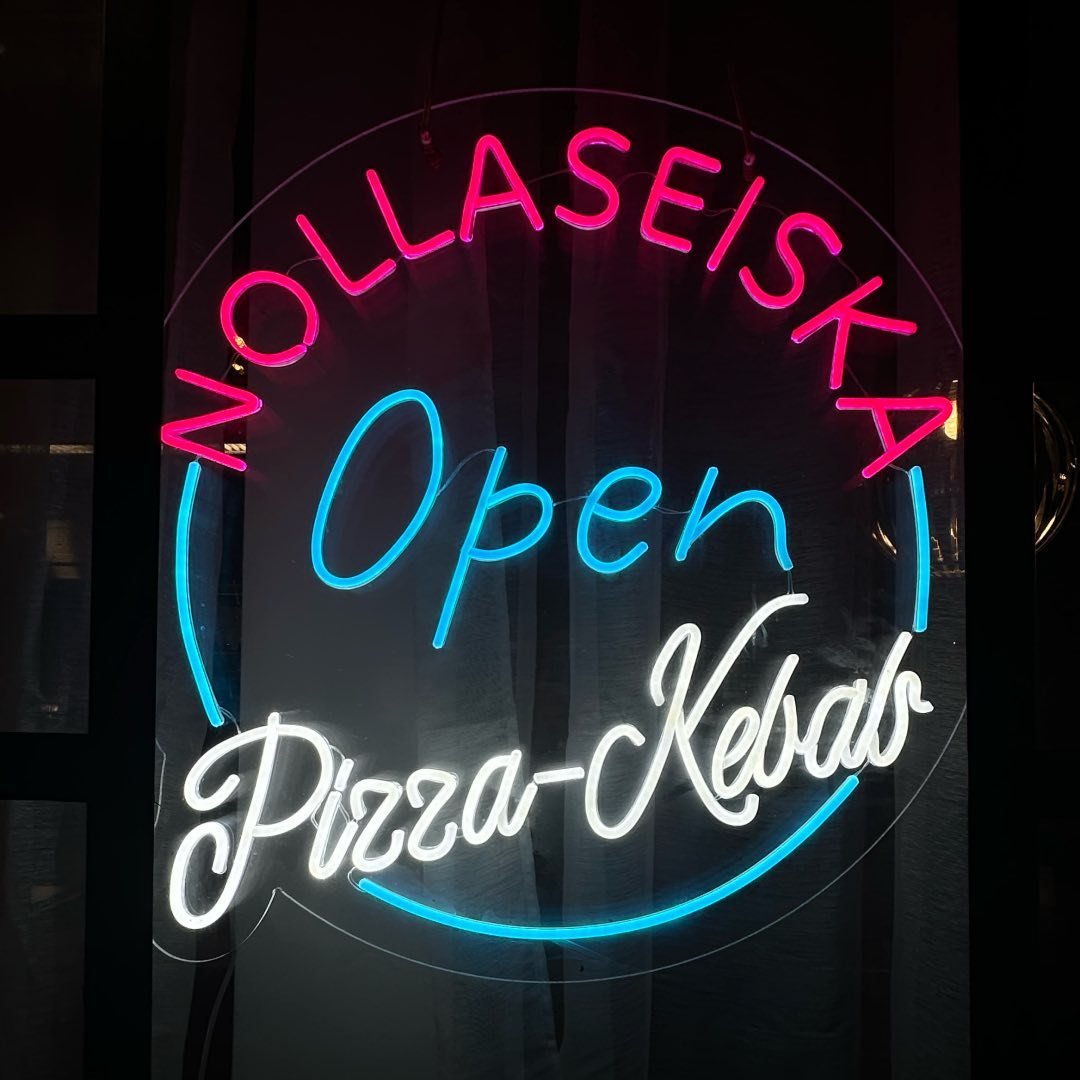 LED-Neonschild mit OPEN-Schriftzug im Schaufenster eines Restaurants