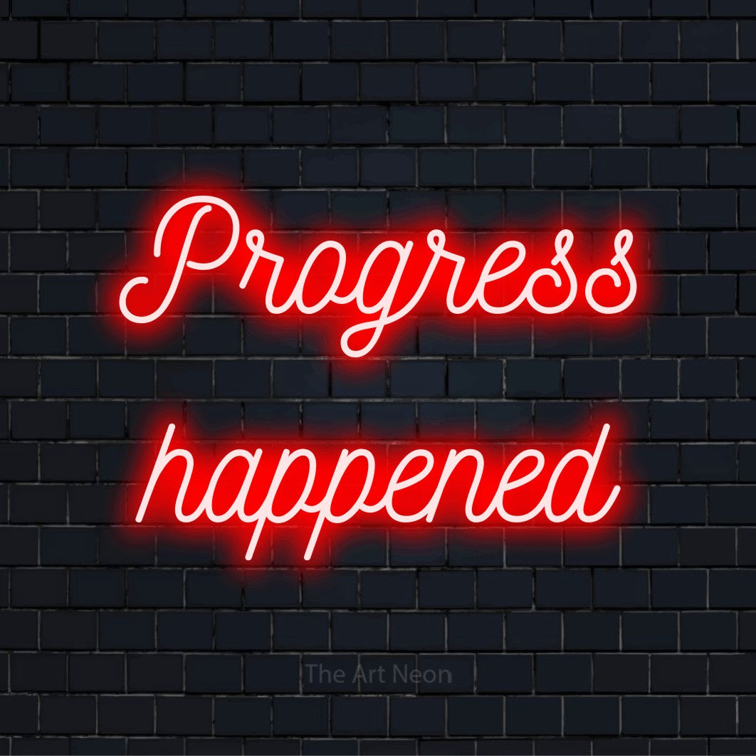 "Progress Happened" script-style LED neon sign on a black brick wall