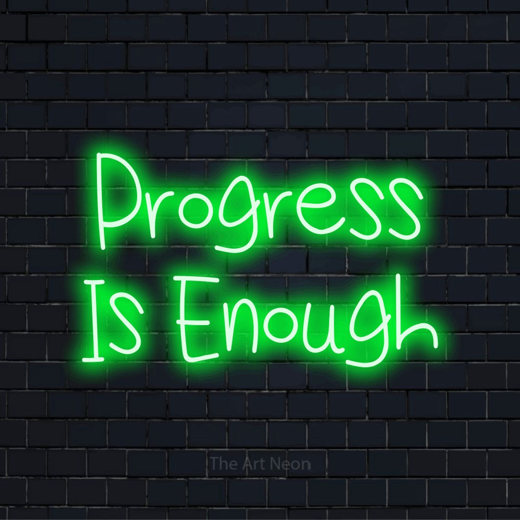 "Progress Is Enough" glowing LED neon sign on a black brick wall