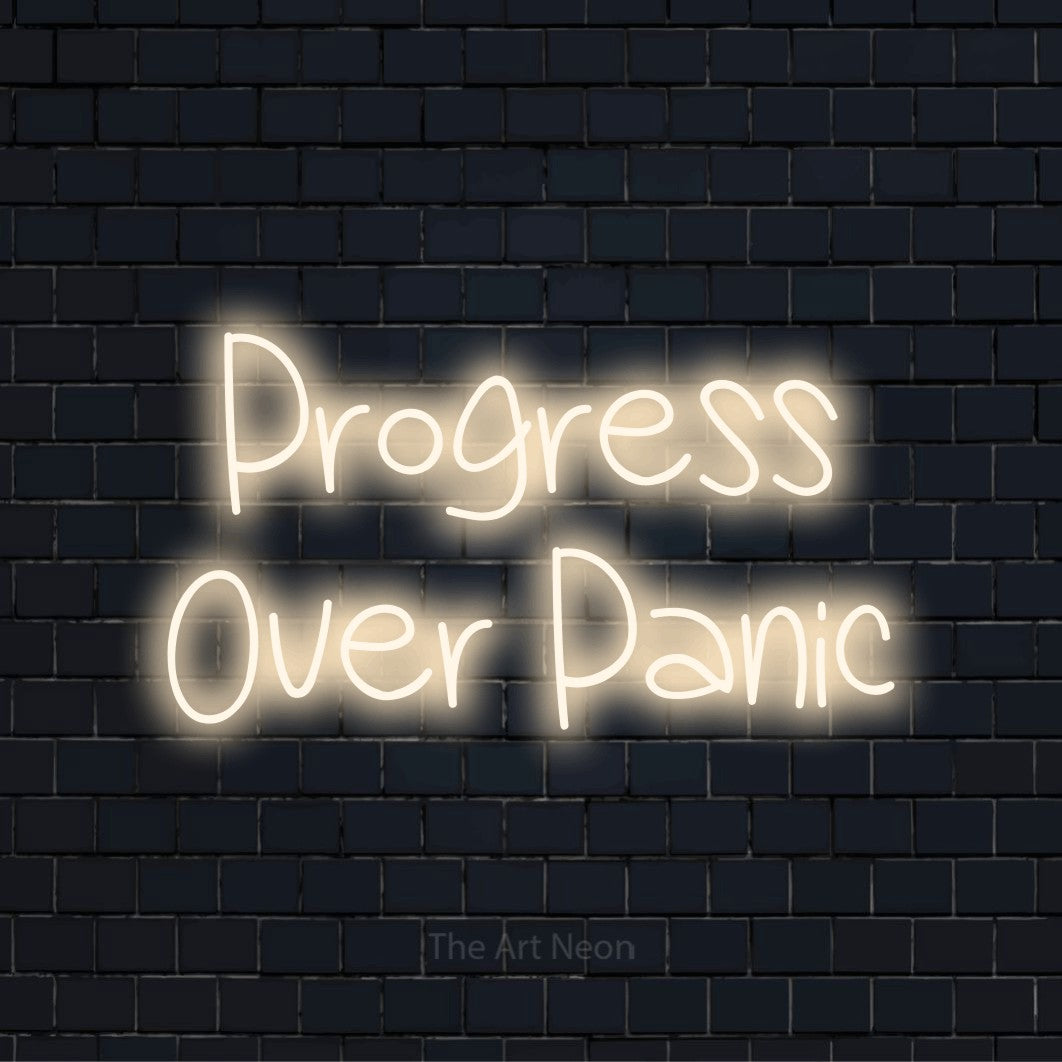 "Progress Over Panic" LED neon sign on a black brick wall