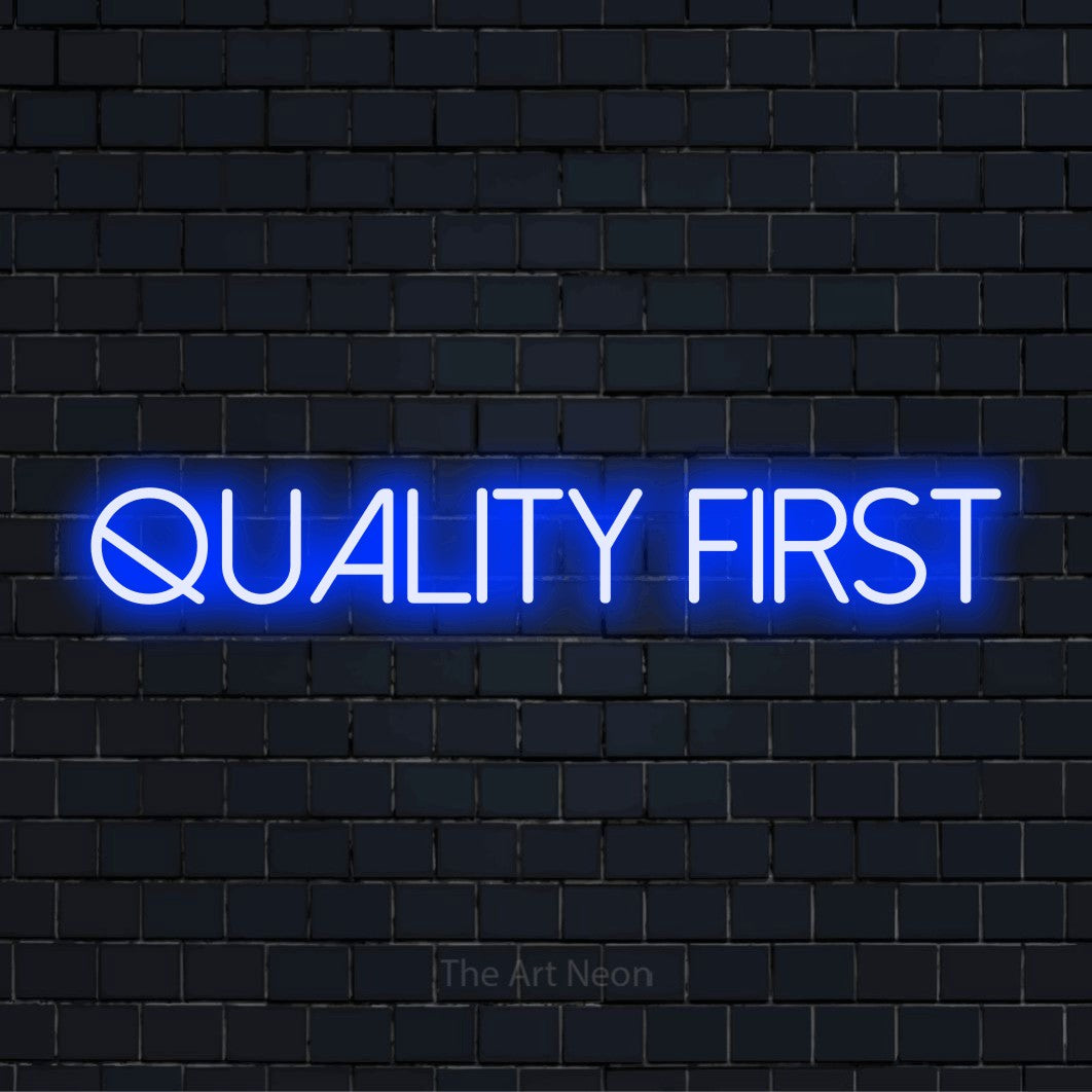 "Quality First" LED neon sign on a black brick wall