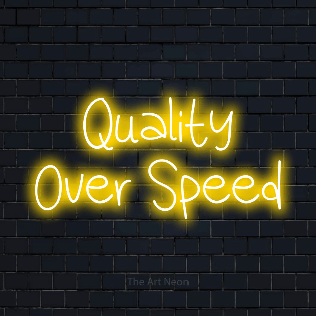 "Quality Over Speed" script-style LED neon sign on a black brick wall