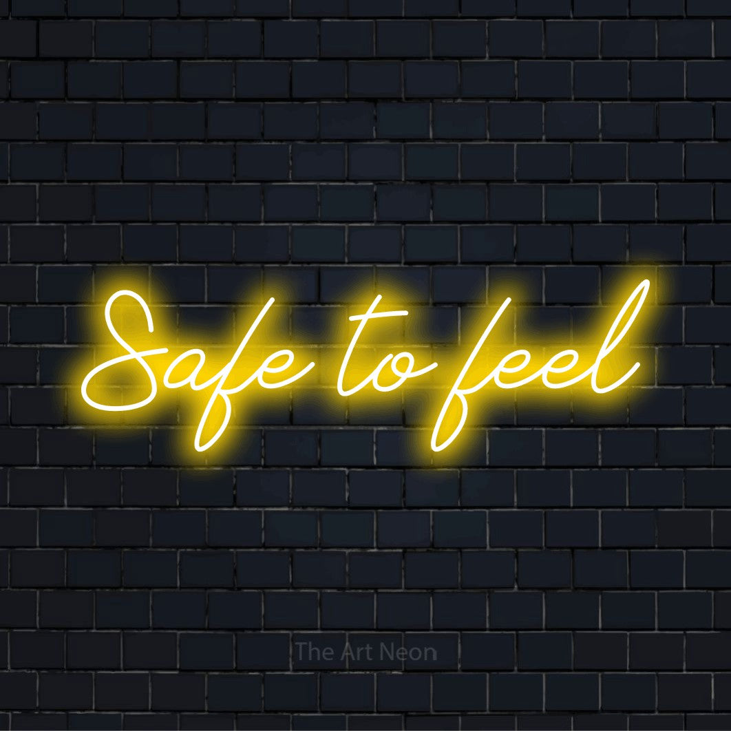 "Safe To Feel" glowing LED neon sign on a black brick wall