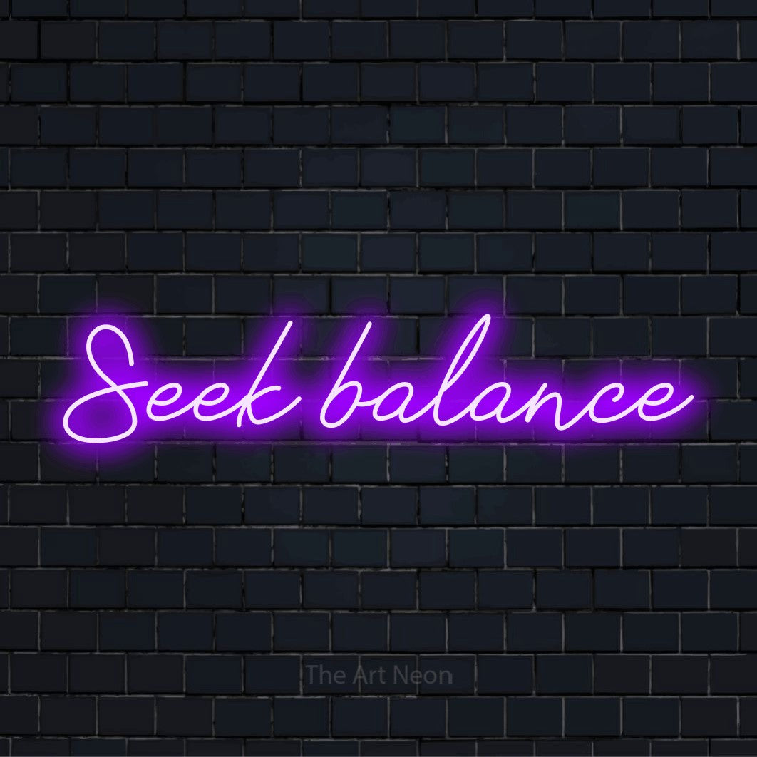 "Seek Balance" script-style LED neon sign on a black brick wall
