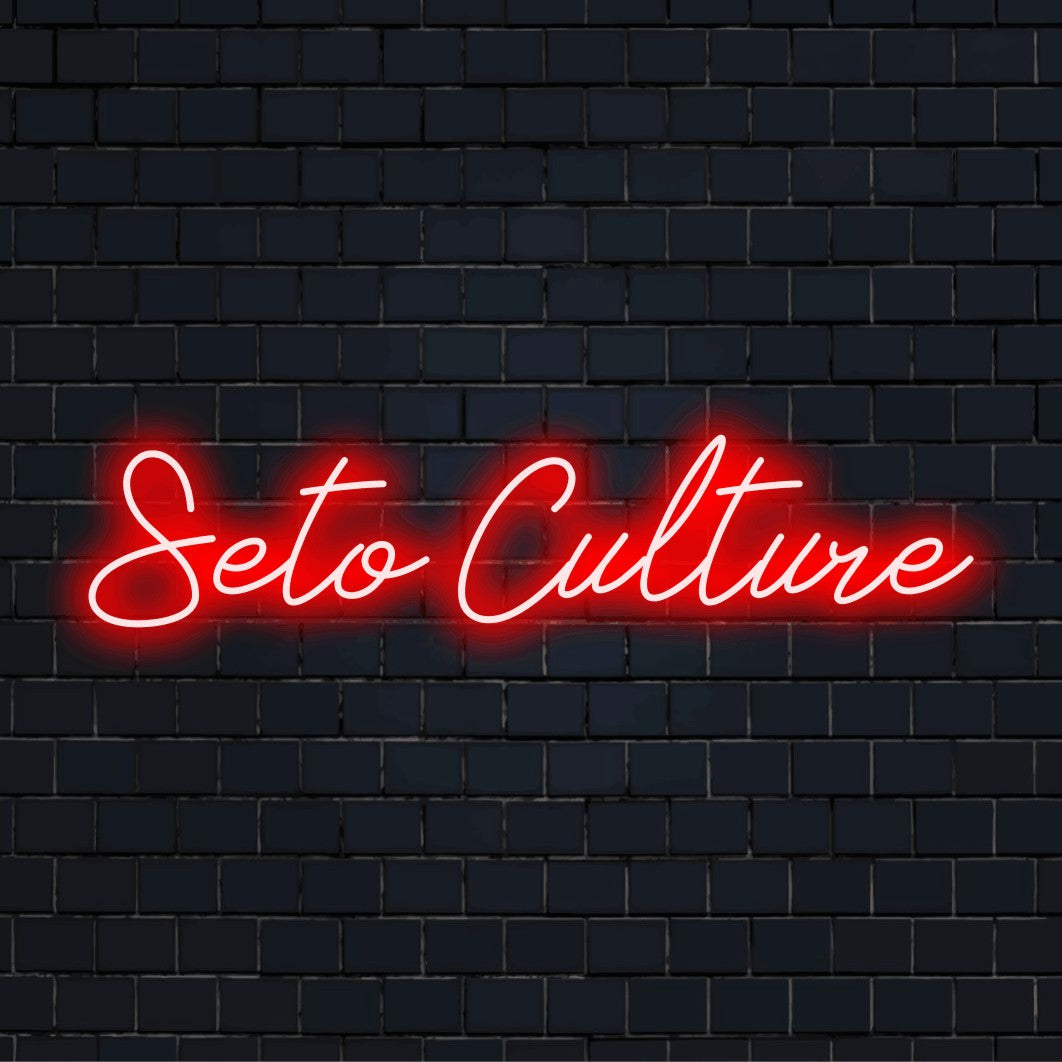 Seto Culture LED Neon Sign, glowing neon text against black brick wall