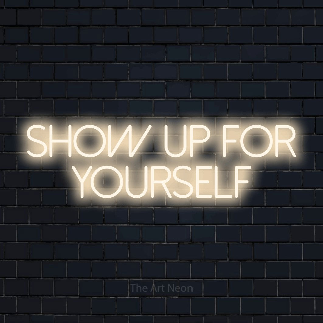 "Show Up For Yourself" text design with neon effect on a black brick wall