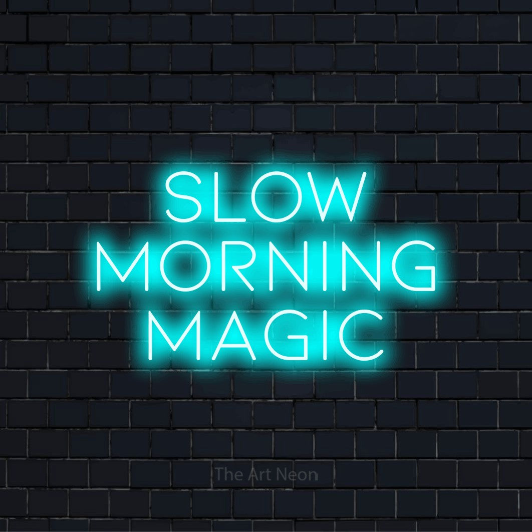 "Slow Morning Magic" LED neon sign on a black brick wall