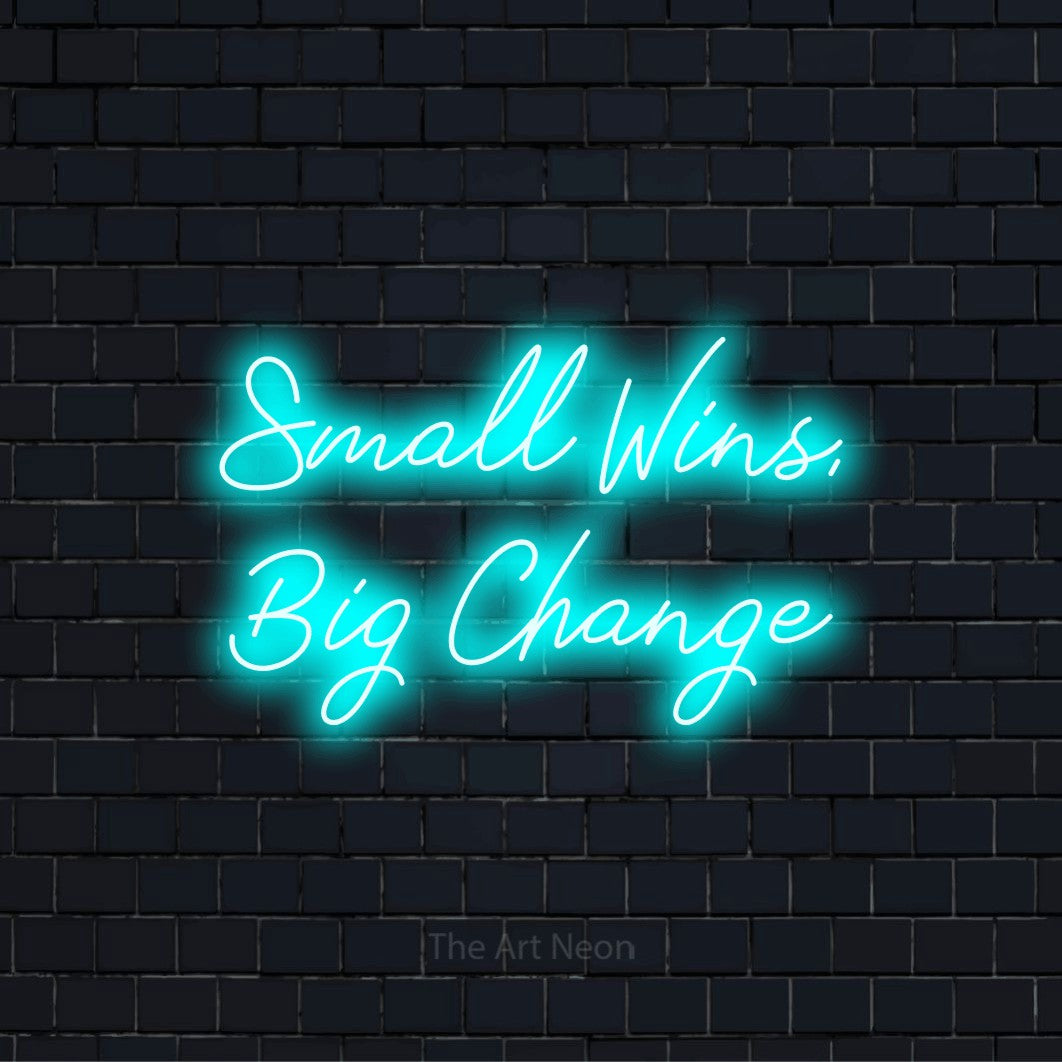 "Small Wins, Big Change" glowing LED neon sign on a black brick wall