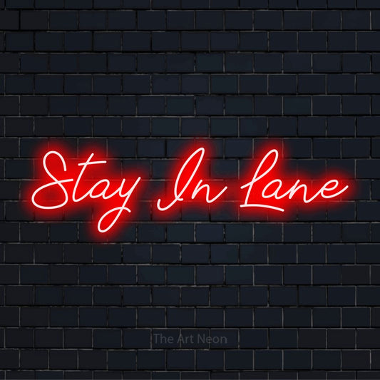"Stay In Lane" text design with neon effect on a black brick wall