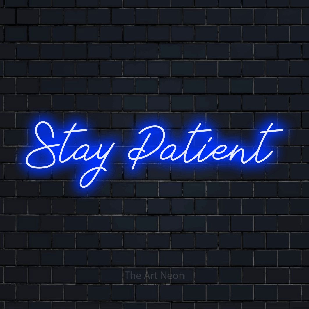 "Stay Patient" script-style LED neon sign on a black brick wall