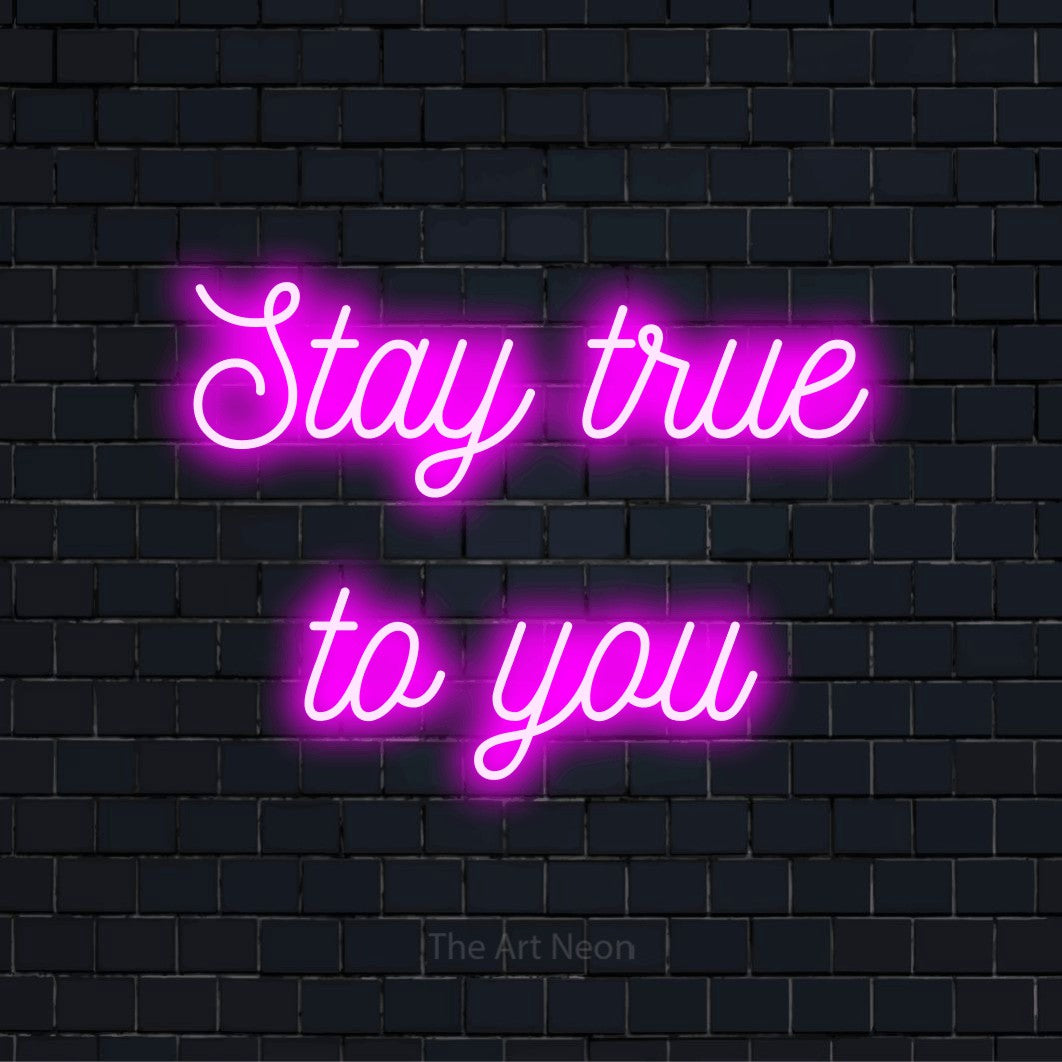 "Stay TRUE To You" script-style LED neon sign on a black brick wall