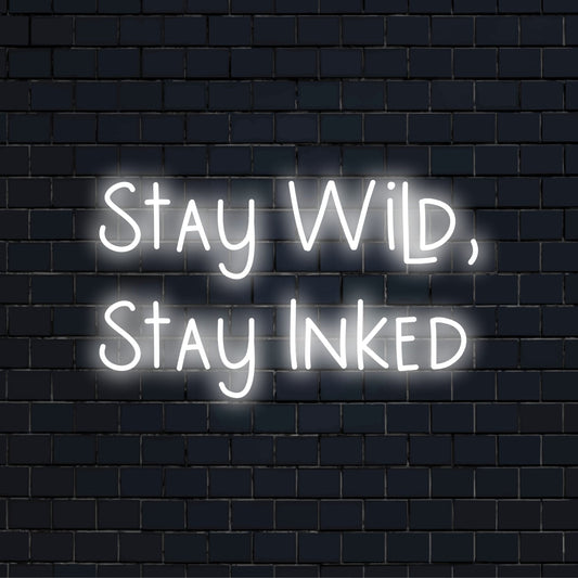 Stay Wild Stay Inked Neon Light with bright LED glow against black brick wall