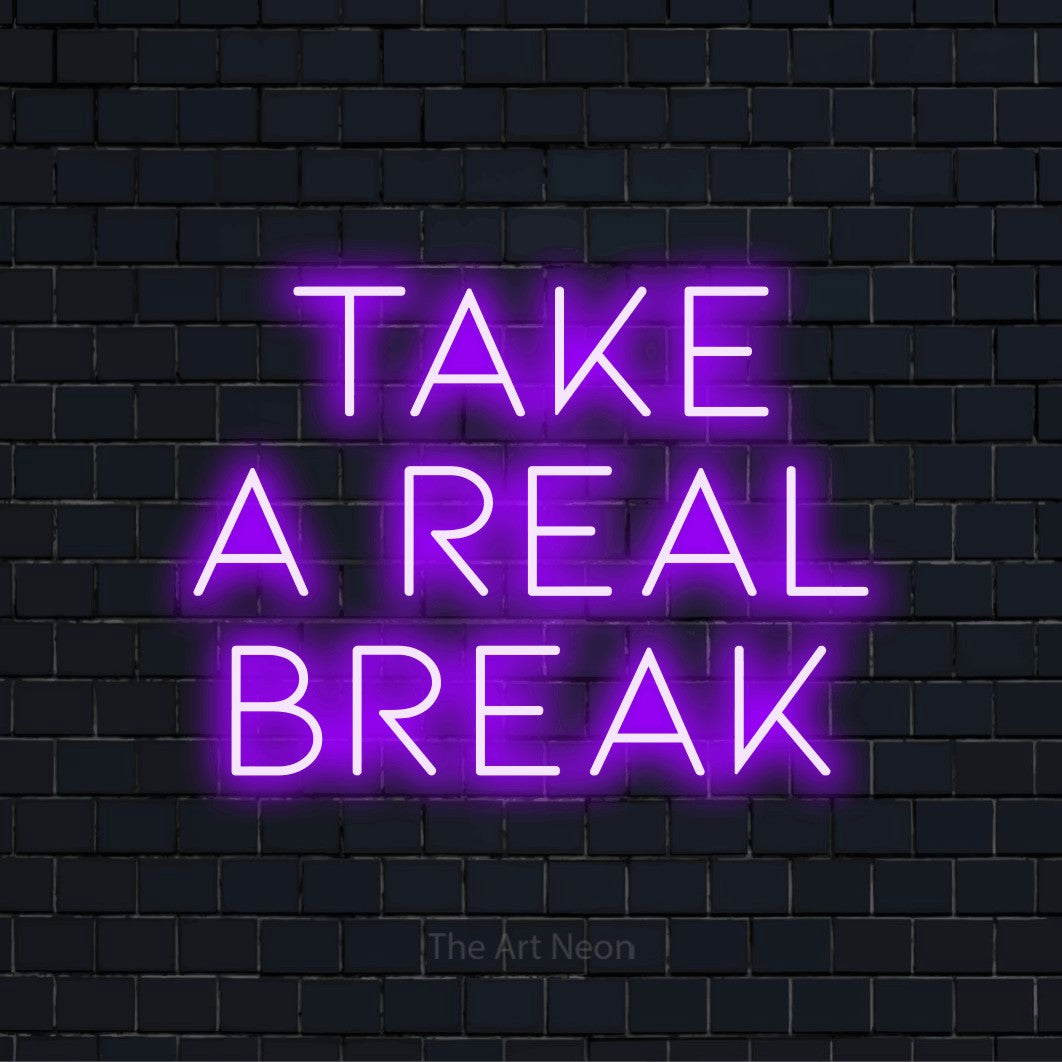 "Take A Real Break" LED neon sign on a black brick wall
