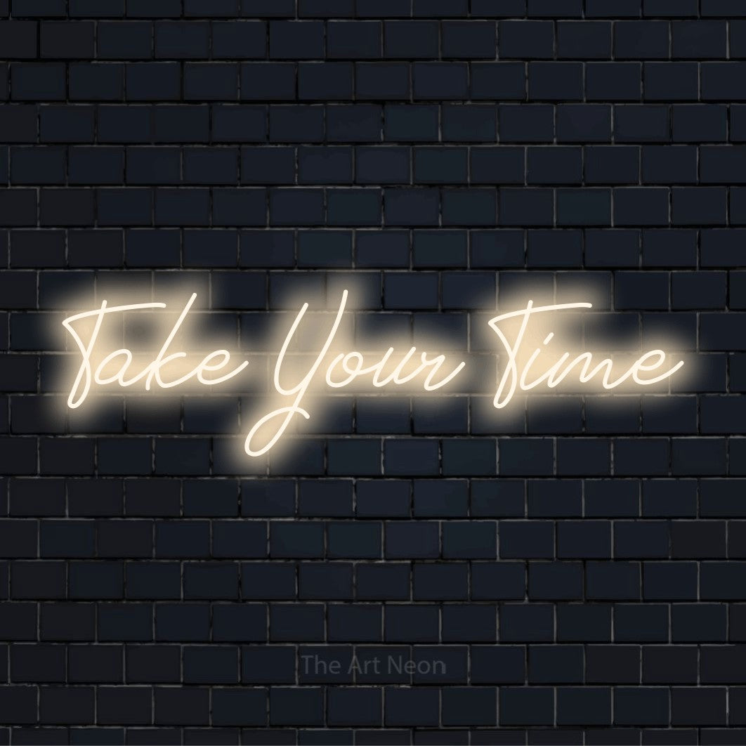 "Take Your Time" script-style LED neon sign on a black brick wall