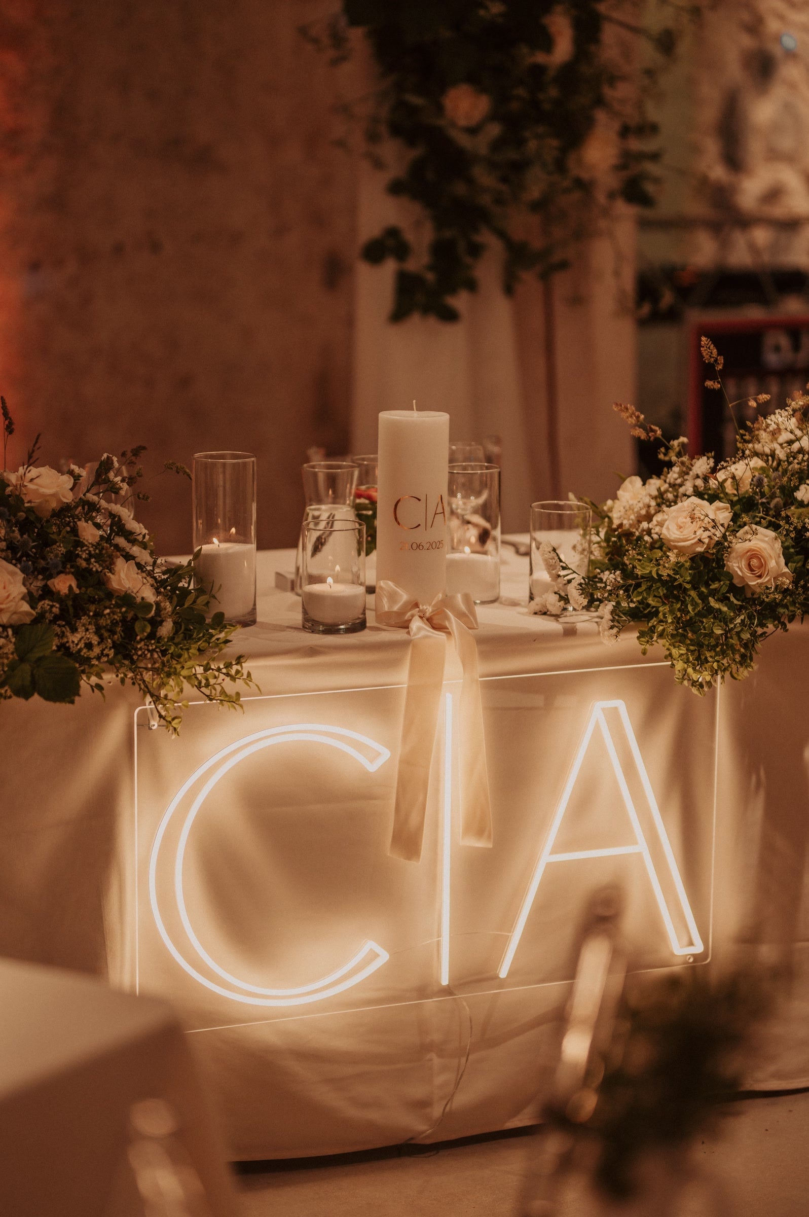 Warm-white C and A initials LED neon displayed on a table for a wedding celebration.