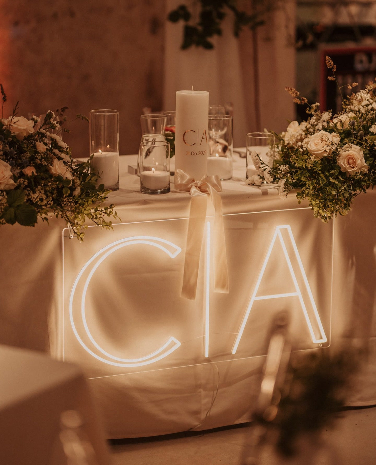 Warm-white C and A initials LED neon displayed on a table for a wedding celebration.