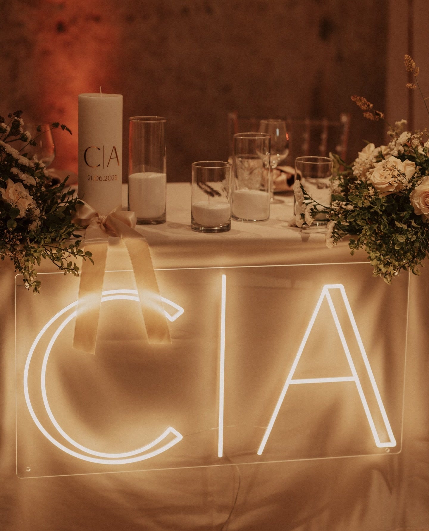 Warm-white C and A initials LED neon displayed on a table for a wedding celebration.