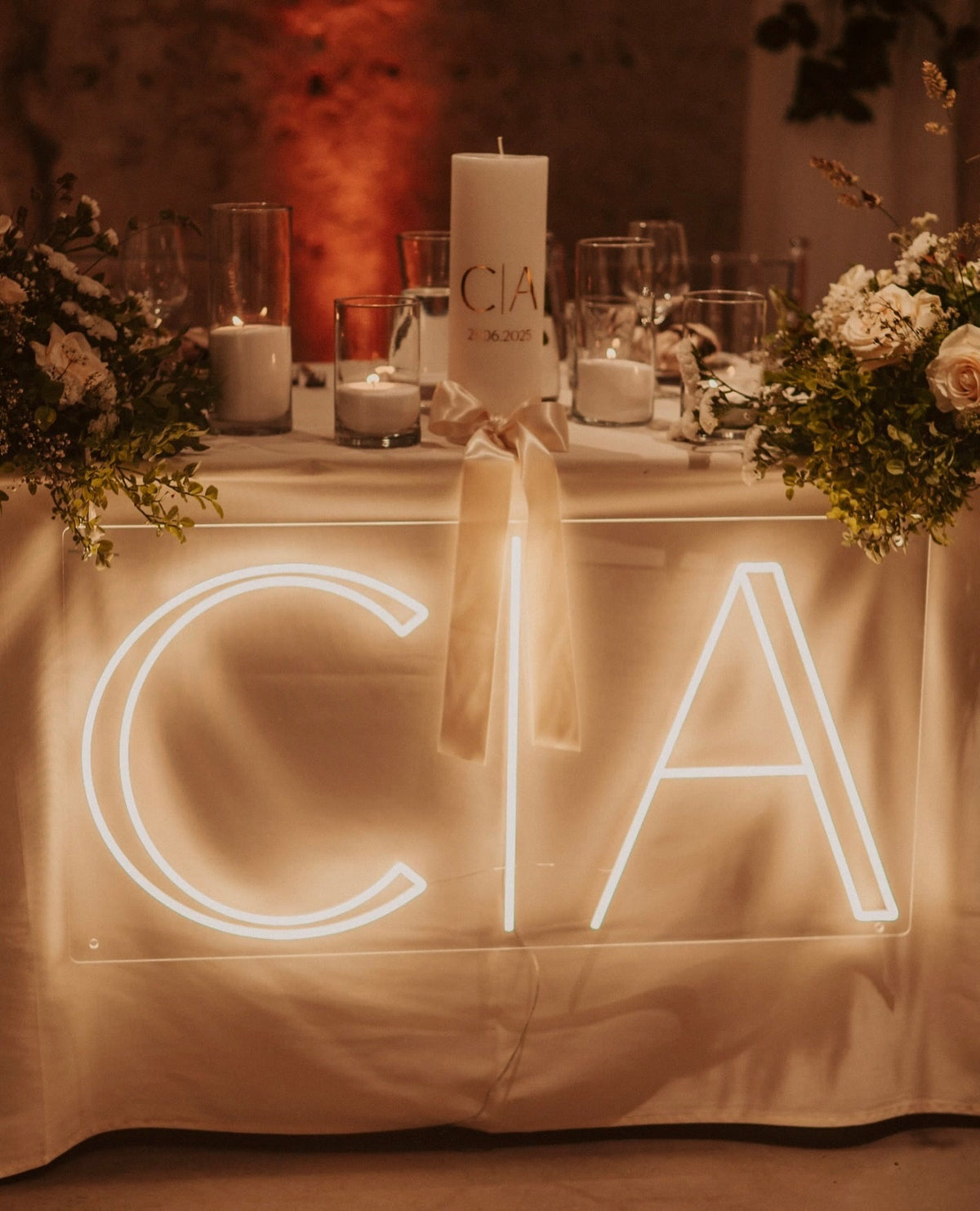 Warm-white C and A initials LED neon displayed on a table for a wedding celebration.
