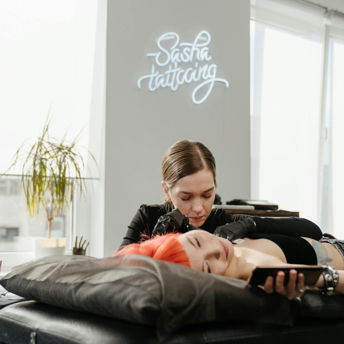 LED-Neonschild mit dem Logo eines Tattoo-Künstlers in einem Tattoostudio