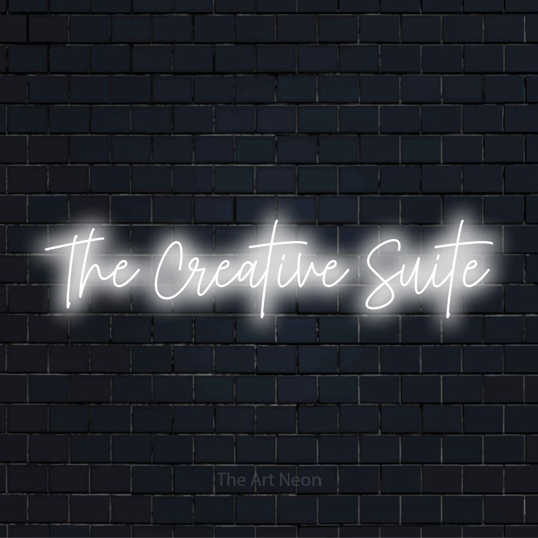 "The Creative Suite" text design with neon effect on a black brick wall