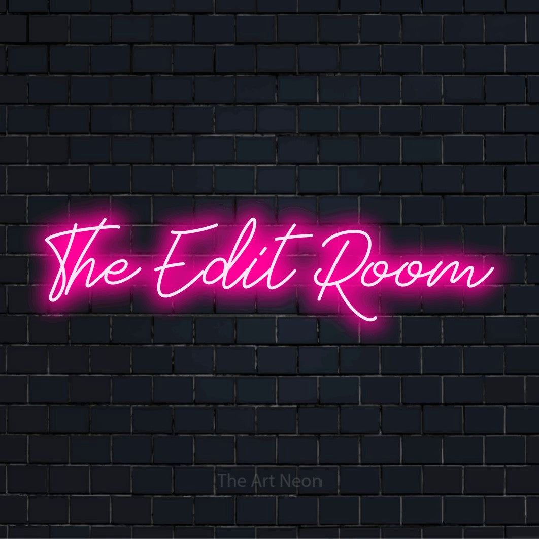 "The Edit Room" glowing LED neon sign on a black brick wall