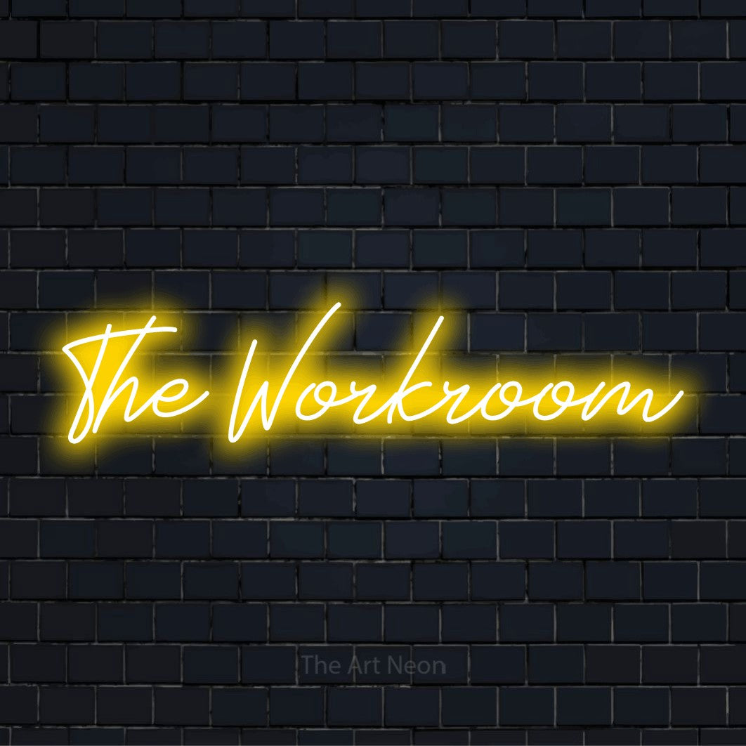 "The Workroom" text design with neon effect on a black brick wall