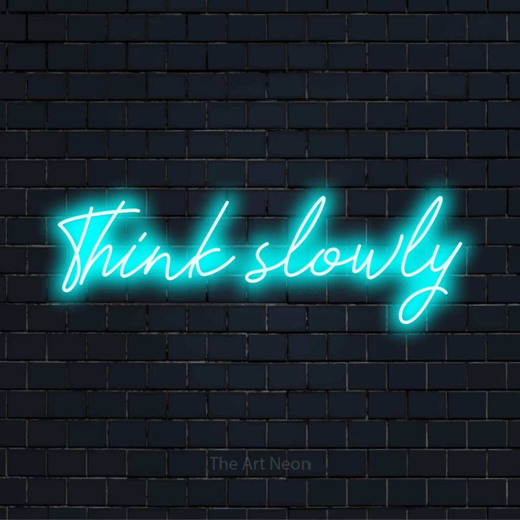 "Think Slowly" glowing LED neon sign on a black brick wall
