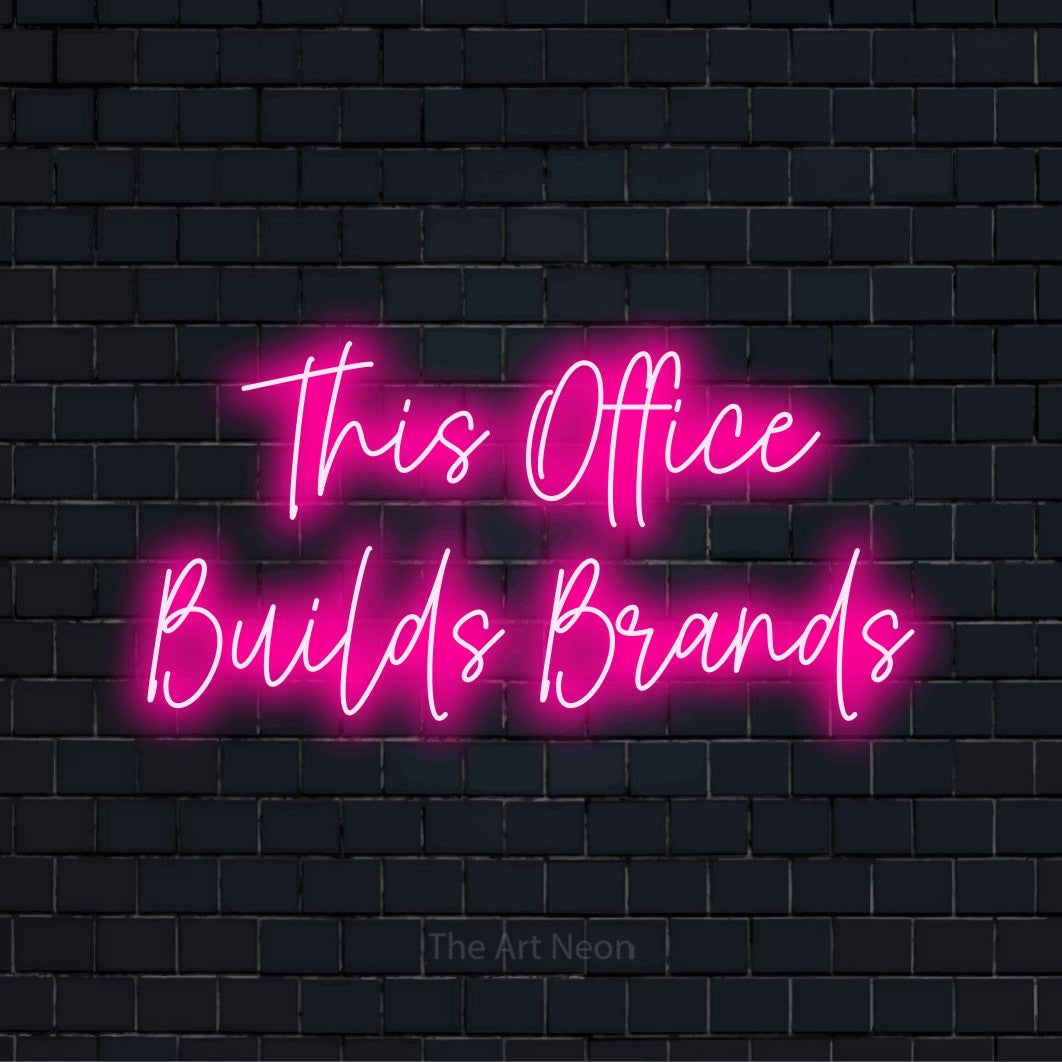 "This Office Builds Brands" neon text design on a black brick wall