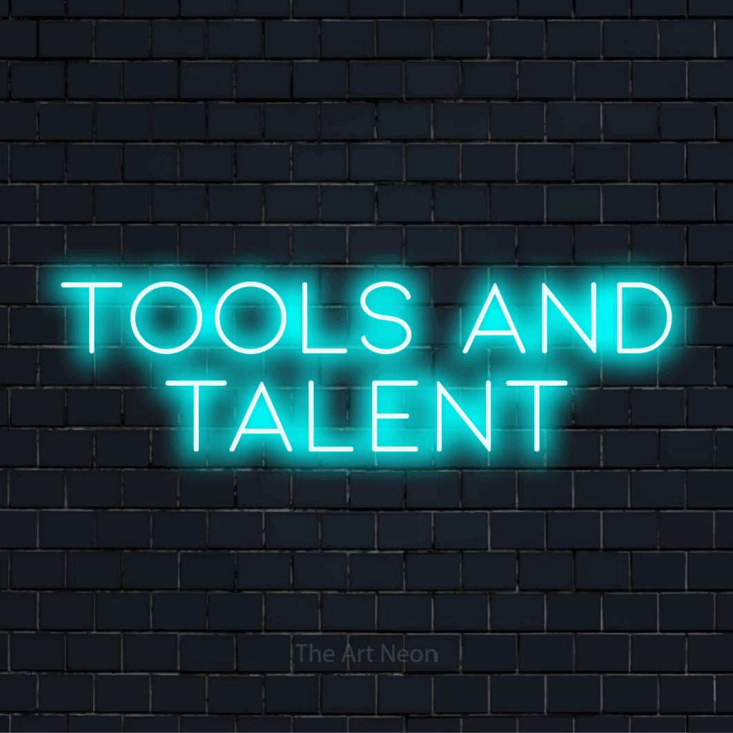 "Tools And Talent" neon text design on a black brick wall